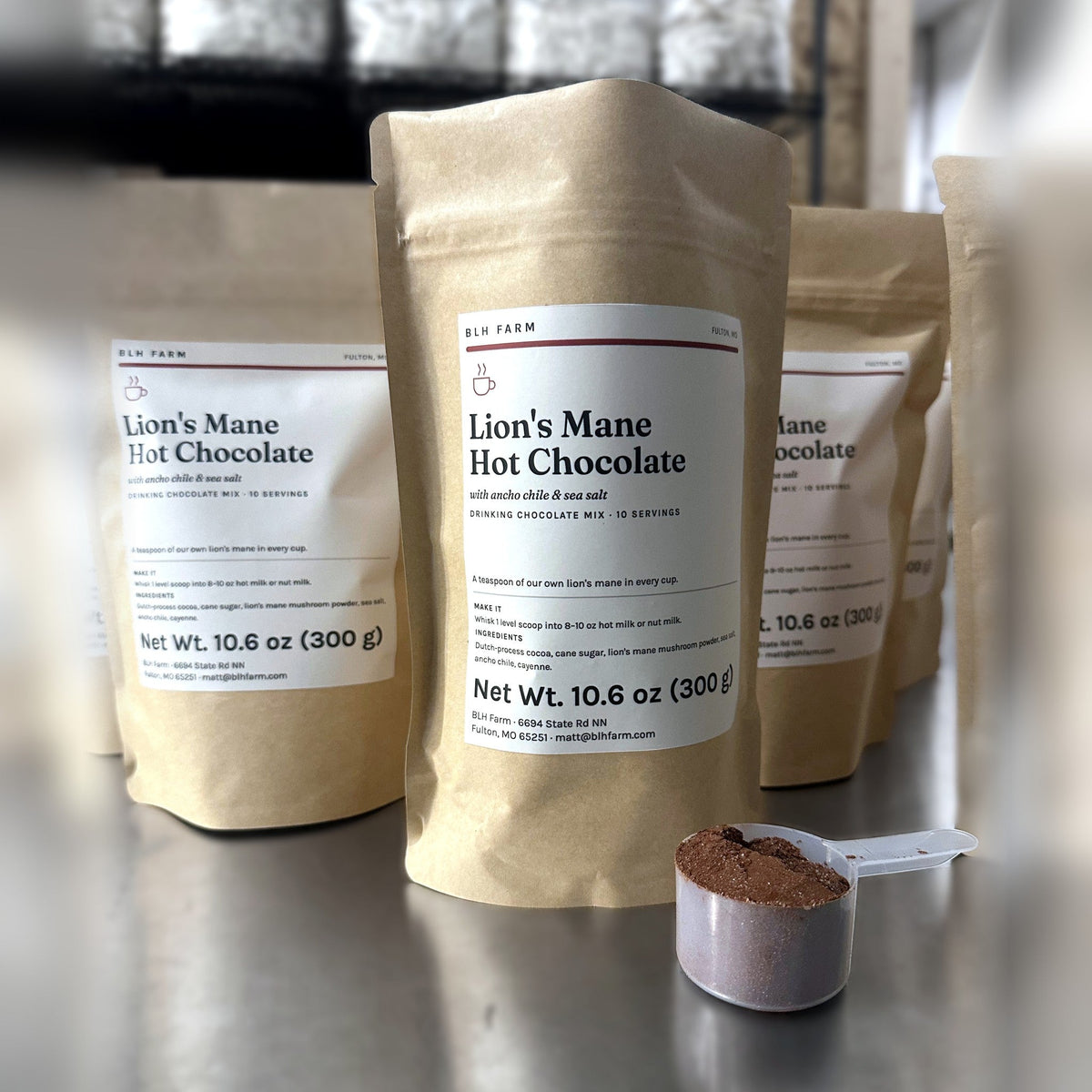 Lion's Mane Hot Chocolate 10.6 oz kraft pouches with a scoop of cocoa mix