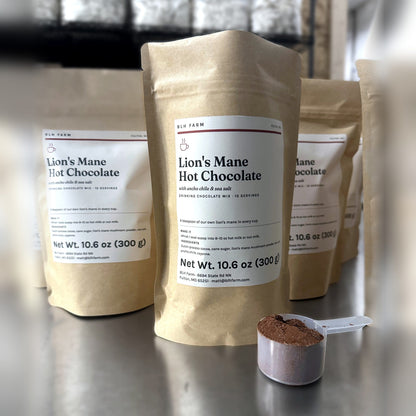 Lion's Mane Hot Chocolate 10.6 oz kraft pouches with a scoop of cocoa mix